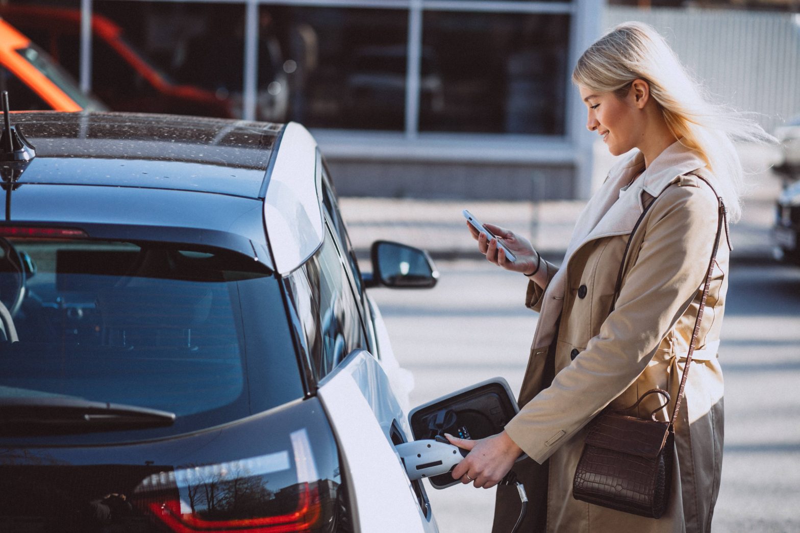 Women looking mobile outside a car